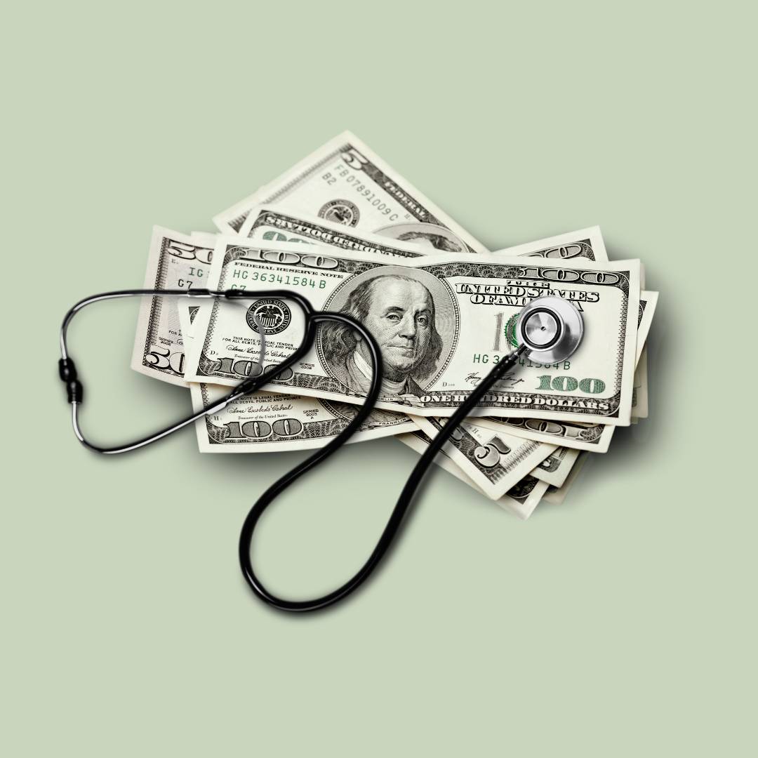 Stethoscope on top of a stack of $100 bills on a light green background. 