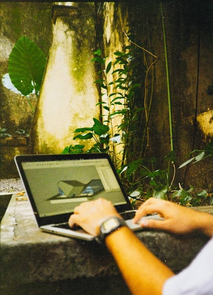 Person using a laptop with architectural design on screen.