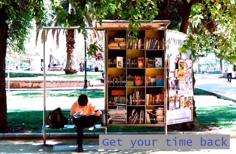 boy sitting on bench beside bookshelf