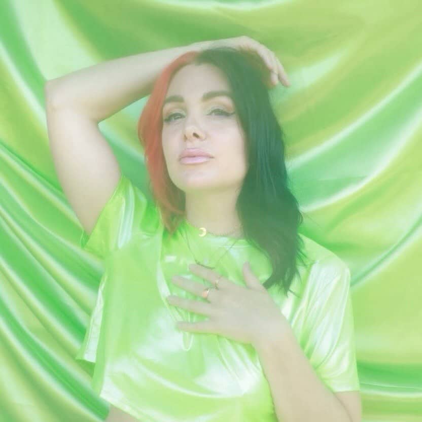 ✨ 👋 Hi Loves, I’m Luna, Co-Founder of Chronically Iconic Club ✨

Living with chronic illness and being disabled has been a journey of immense grief and transformation. As an educator, death doula, and embodiment guide, I’ve spent years supporting others through life’s transitions, but facing my own health journey and the struggle to take my power back revealed just how essential community is.

I co-founded Chronically Iconic Club to create the support I longed for: a space to show up as we are, connect with others who understand, and honor the strength it takes to live with chronic illness. Here, we’re all iconic, finding power in our shared stories and lifting each other up.  I love this community ! 💕

[ID: 	Image 1 - Luna poses with a hand on their head, wearing a neon green top against a green fabric background.
	Image 2-	Luna lies with a blue heating pad on their shoulders, looking up with a relaxed expression.
	Image 3-	Luna wears a face mask with one hand on their neck, in front of a breast cancer awareness wall with pink designs.
	Image 4- Luna lies next to a fluffy cat, smiling gently with eyes closed as the cat nuzzles their head. 
  Video- Luna on a bridge at sunset, lifting her pink cane up and then putting it down.
 Image 5-Luna smiles brightly, looking up, with a purple flower in hand and petals around their eyes against a neon green background. ]