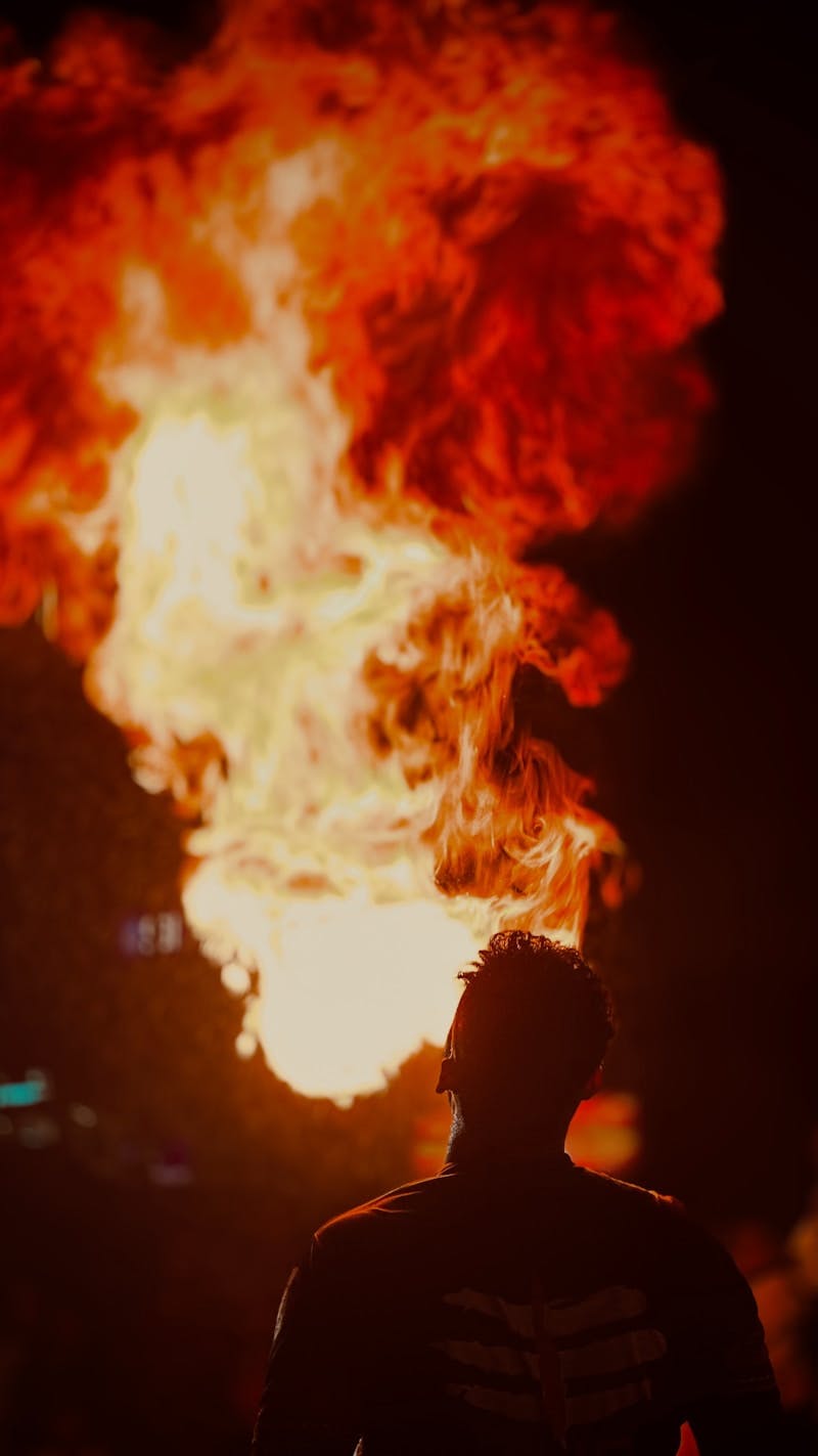 A man standing in front of a large fire