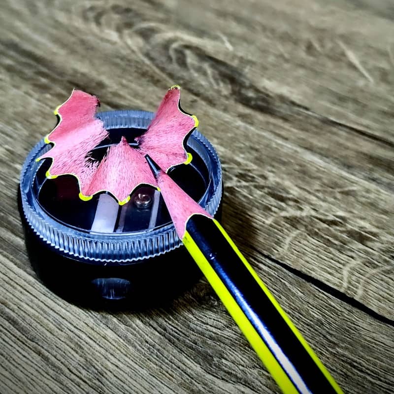 A pink and black object sitting on top of a wooden table