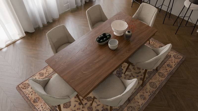 A dining room table with chairs and a rug on the floor