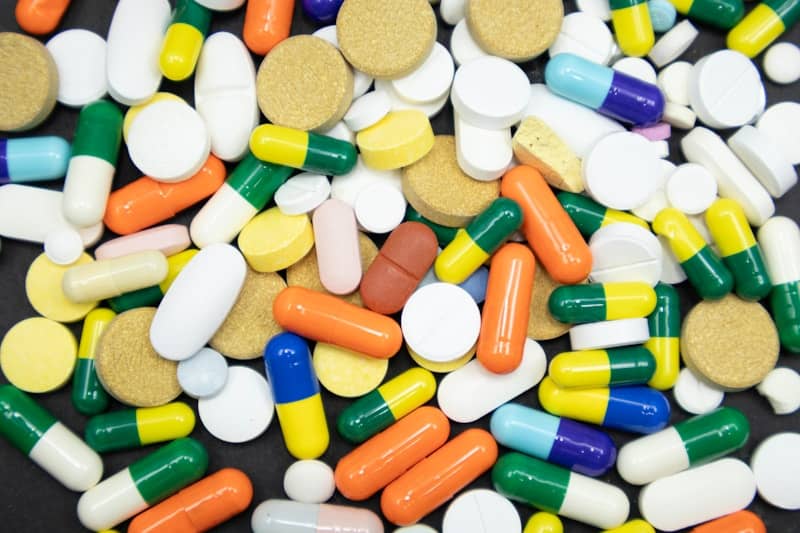Assortment of colorful pills and capsules scattered randomly.