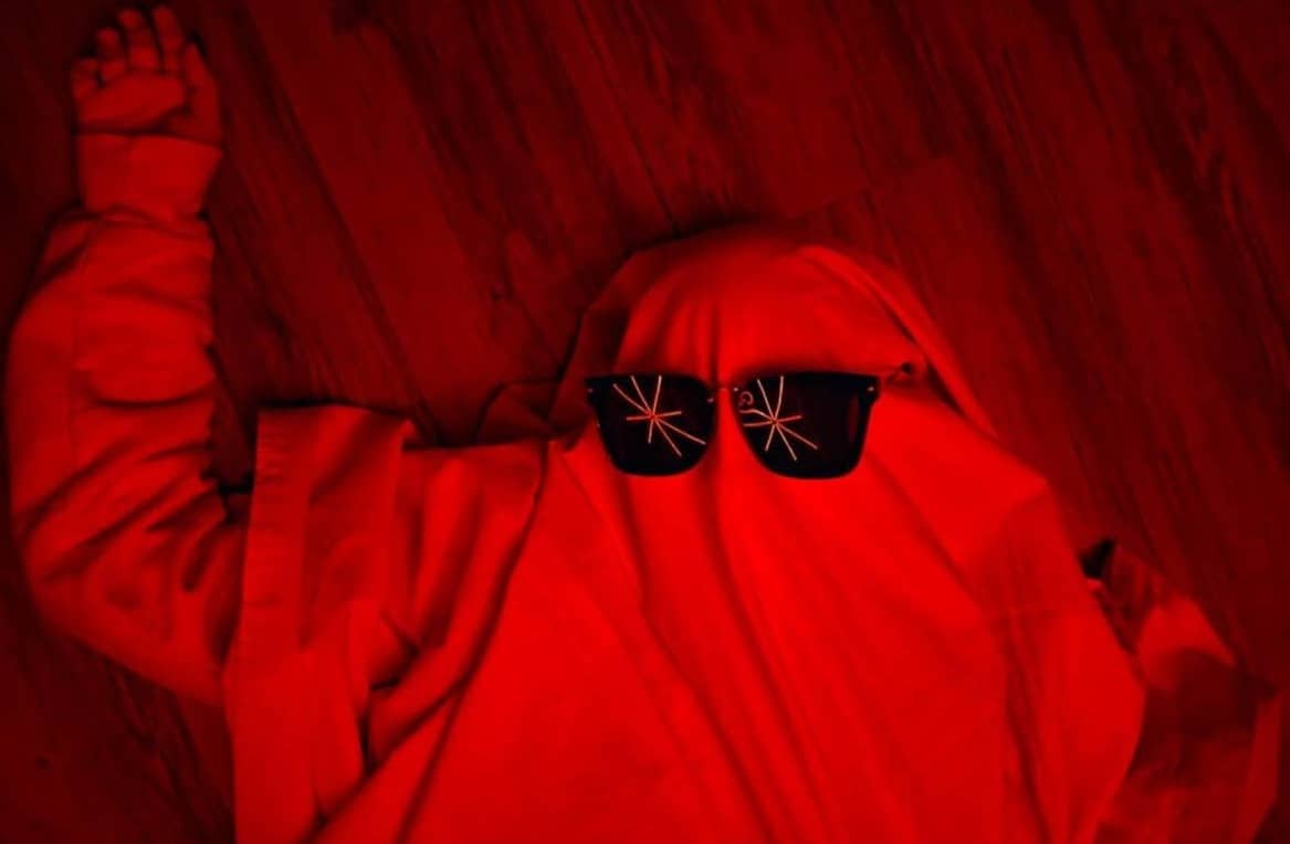 A person lying on the floor with sunglasses