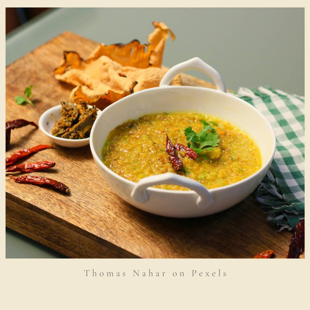 A bowl of khichdi with pickle and papad