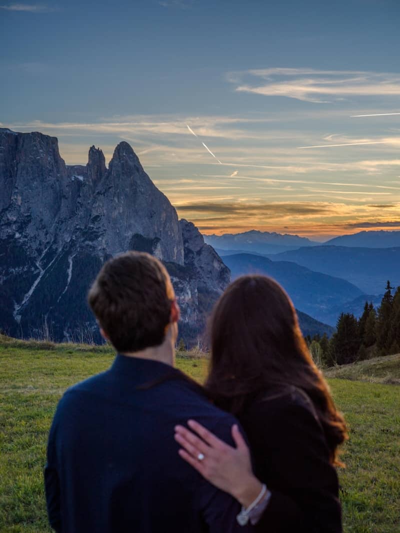 Couple embraces while watching a mountain sunset