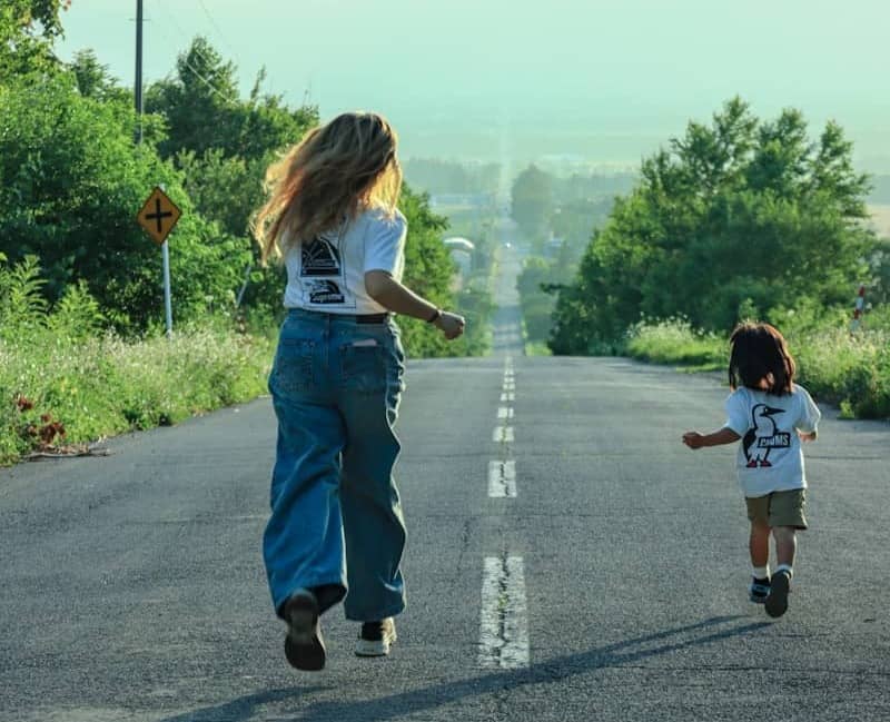 Woman and child running on an empty country road.