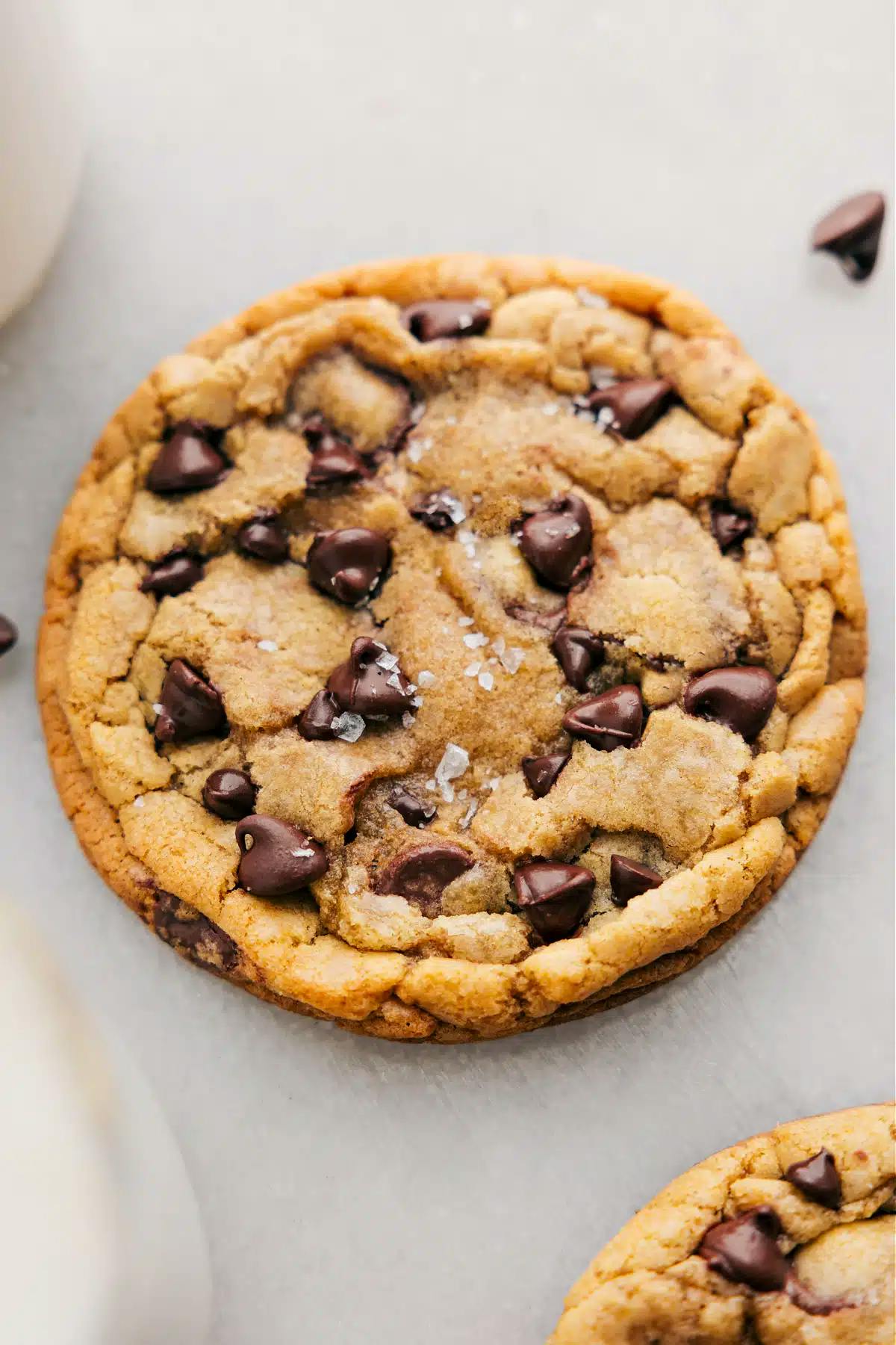 1 large cookie on a board with sprinkle of sea salt on top and chocolate chips