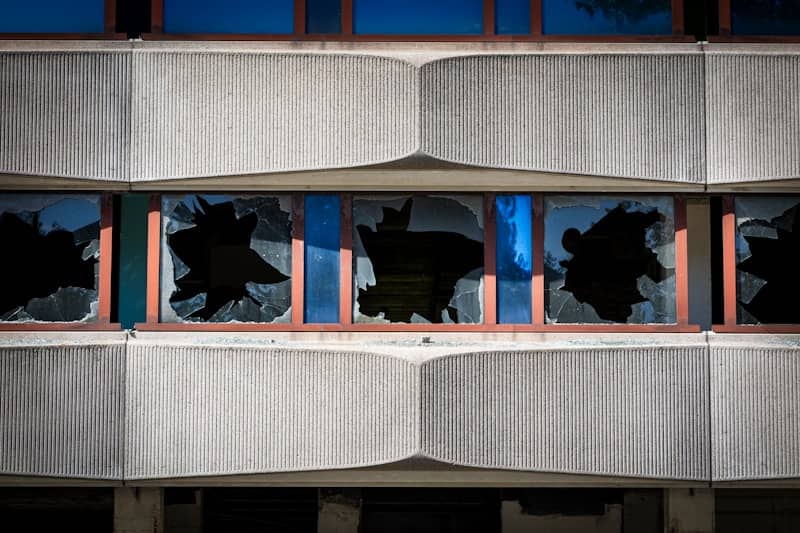 Broken windows on a concrete building facade.
