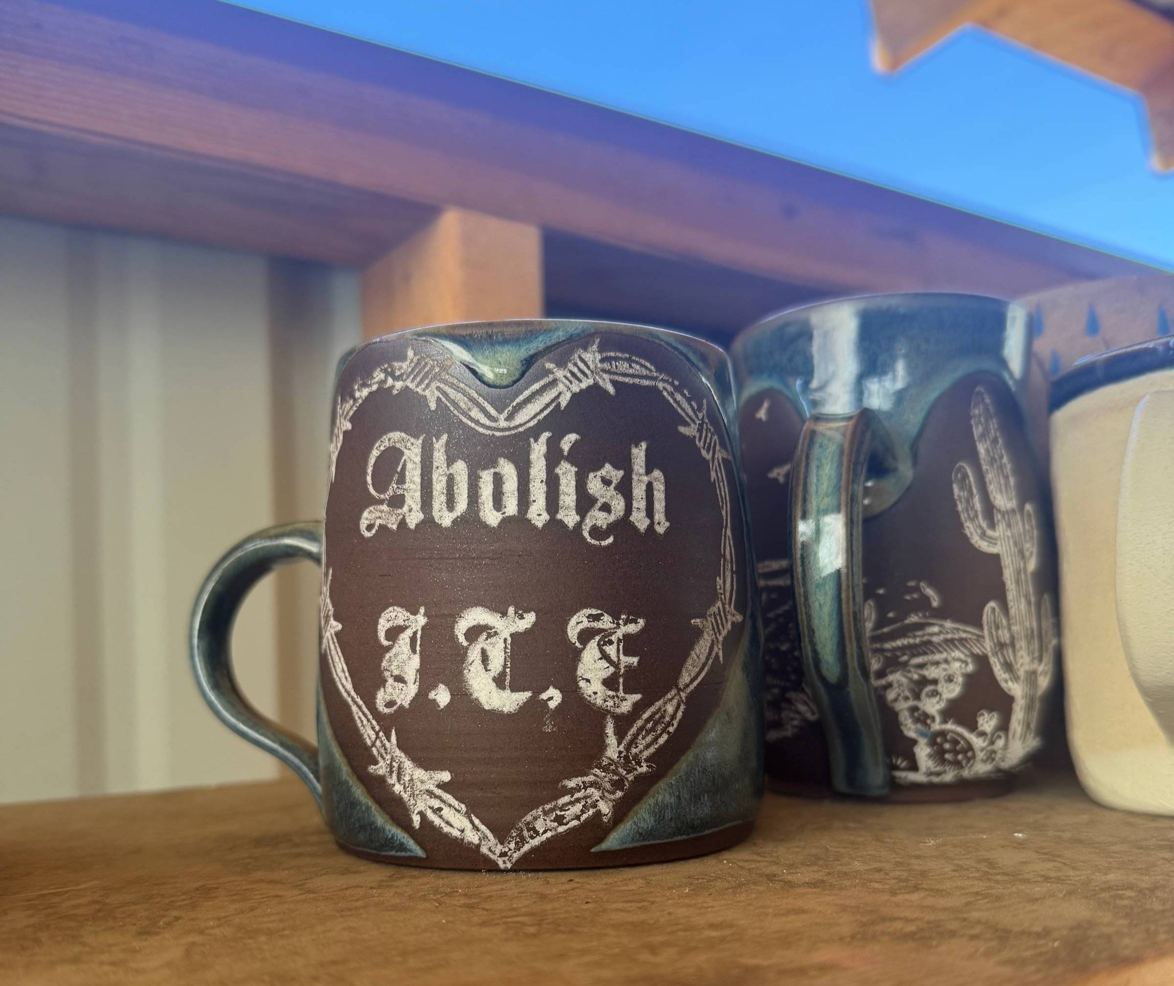 turquoise mug with fancy white script: Abolish ICE
