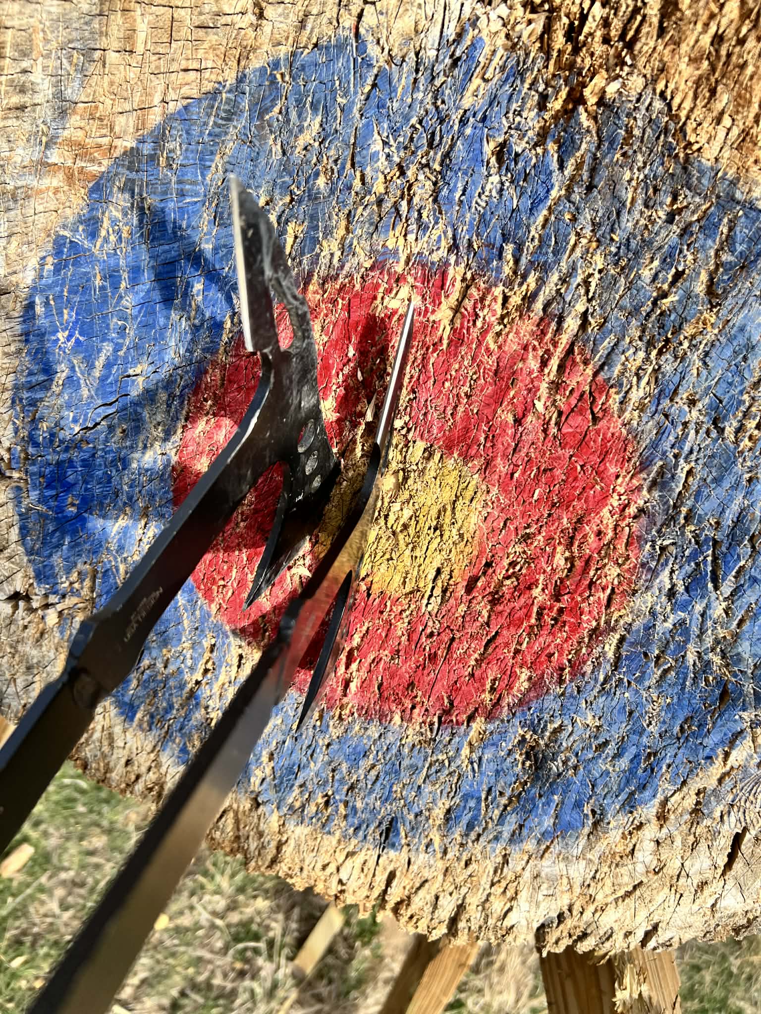 Two axes bstuck in a bullseye about a half inch apart.