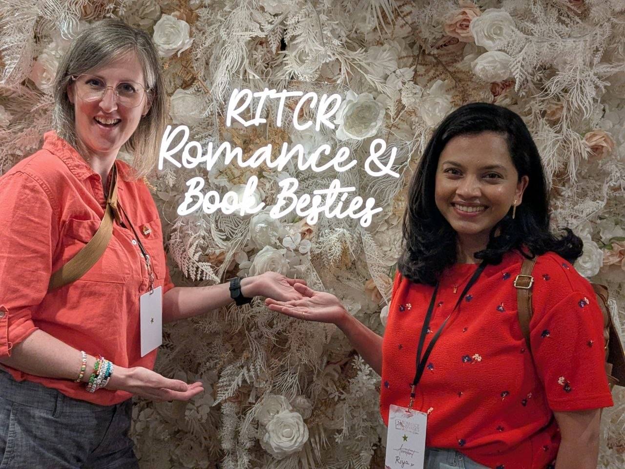 Hannah Brixton and Riya Iyer posing next to neon sign that says RITCR Romance & Book Besties