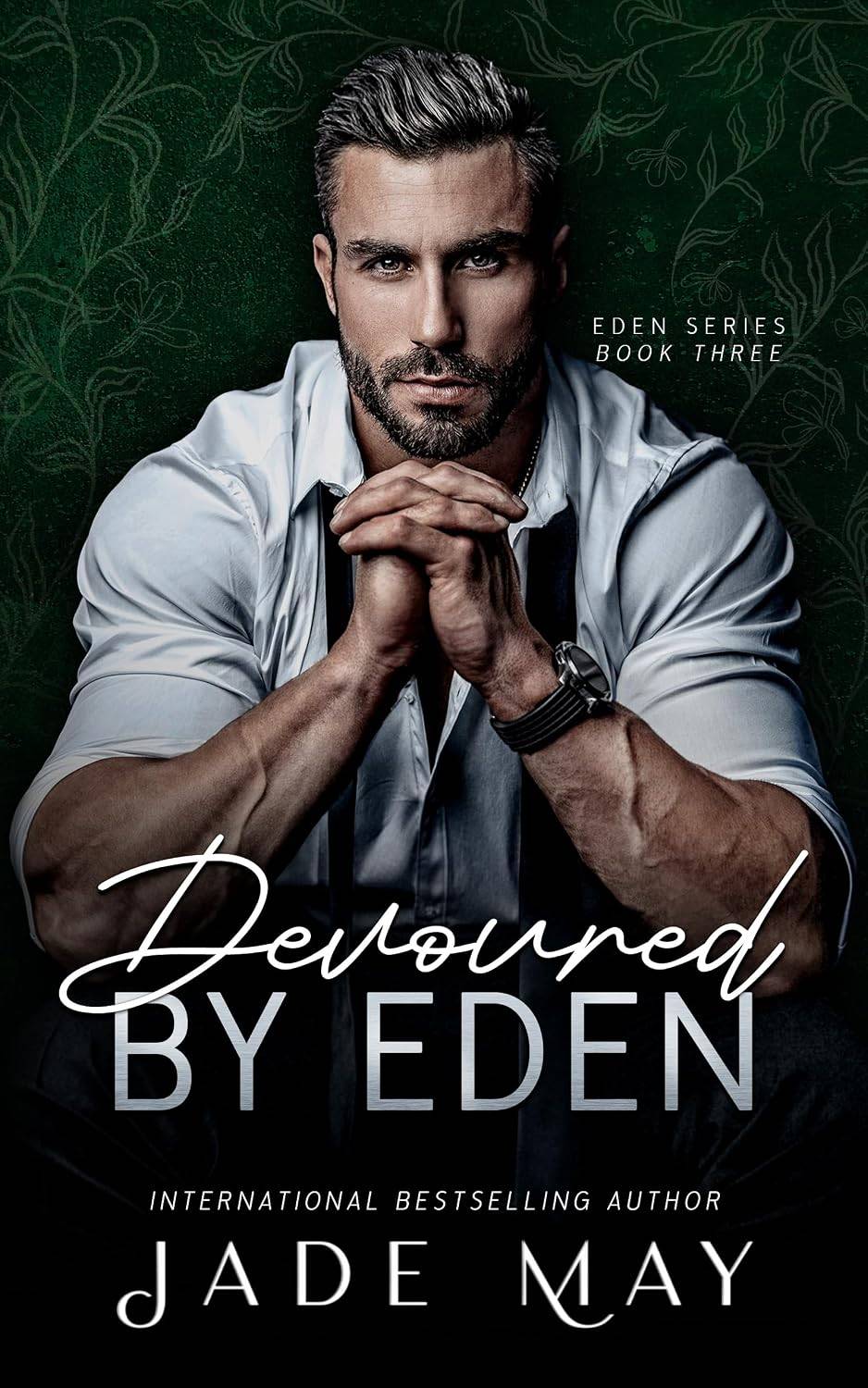cover of Devoured by Eden by Jade May featuring a bearded man facing camera looking over his interlaced fingers in front of a dark background.