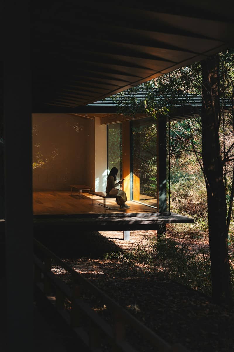 A person sitting in a modern house bathed in sunlight.