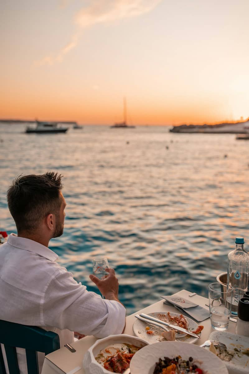 Man enjoying sunset dinner by the sea in fira