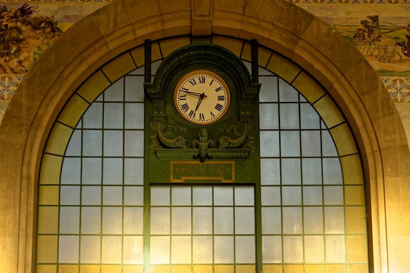 Ornate clock above a large arched window.