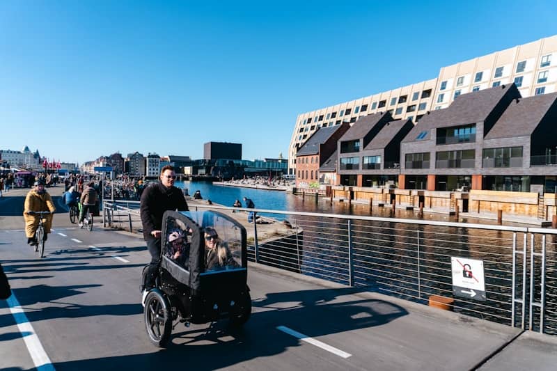 A person bikes with children in a cargo bike.