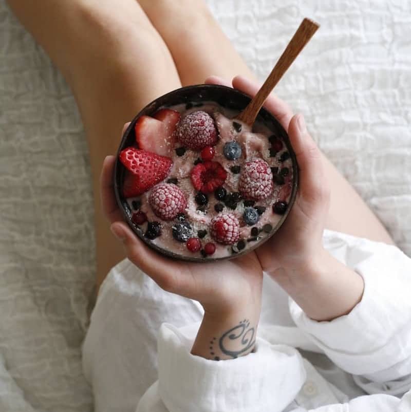 person holding bowl of strawberries