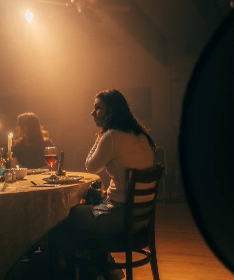 a woman sitting at a table in a dimly lit room