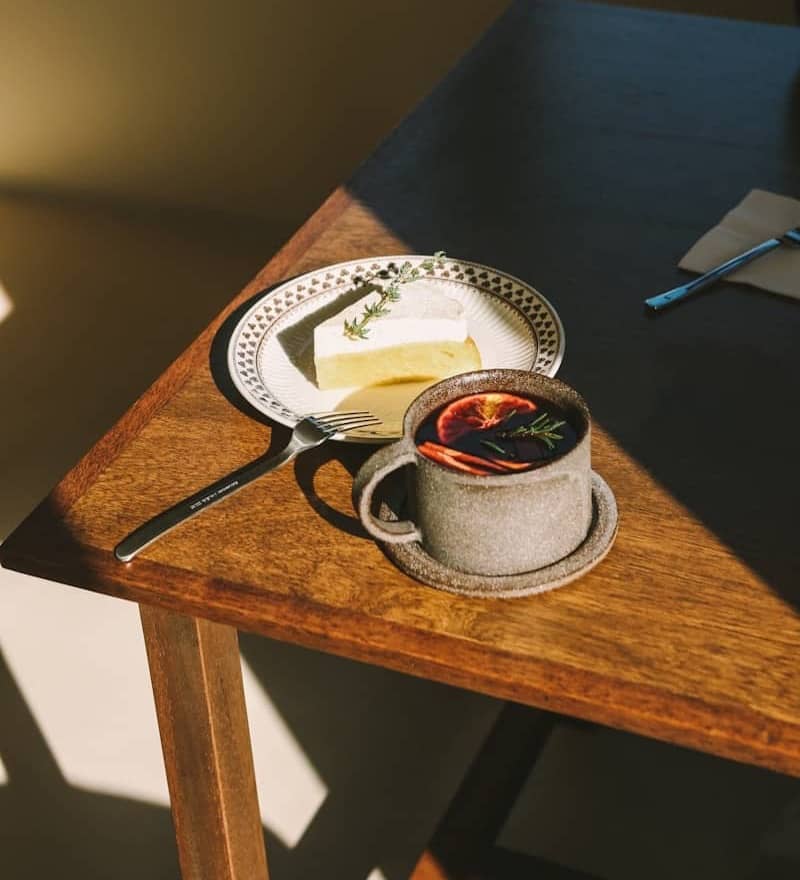 Slice of cake and cup of hot drink on table