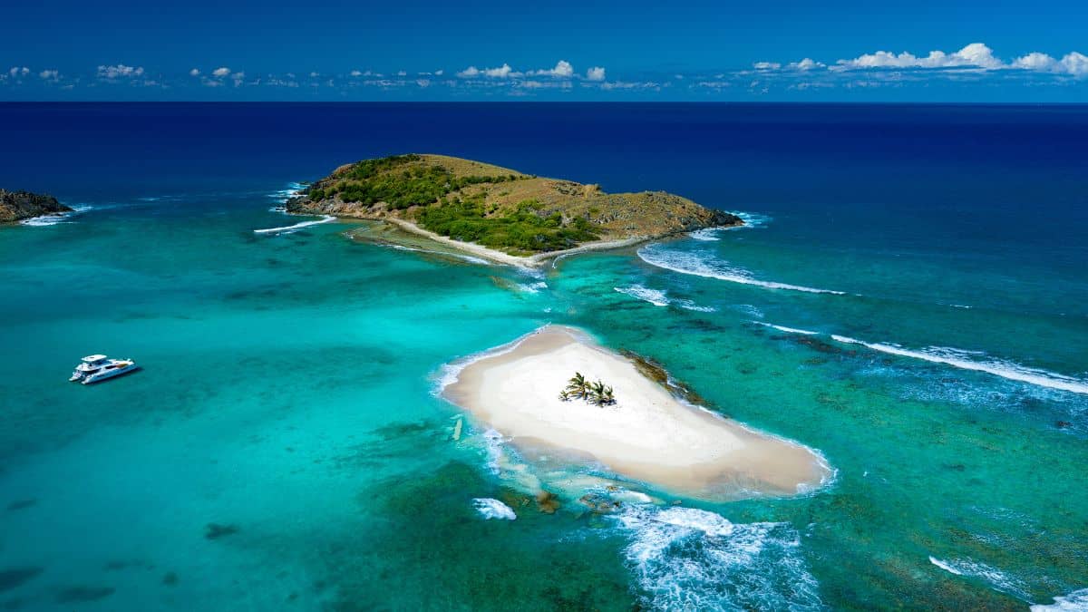 Sandy Spit: a tiny sandbar with a few palm trees, surrounded by classic Caribbean blue.