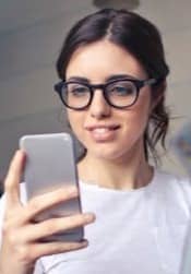 woman in white shirt using smartphone