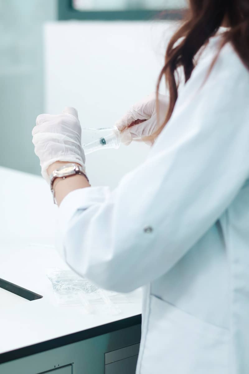 Scientist in lab coat prepares medical sample.