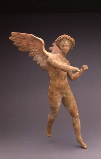 A large statue of a youthful Eros in flight, with traces of blue and gold on his wings and red in his hair 