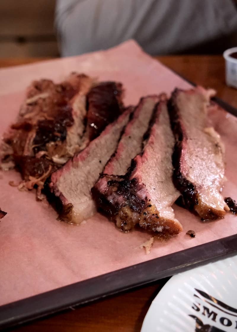 Sliced smoked brisket on pink butcher paper