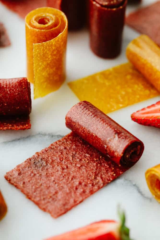 Homemade fruit leather rolled on a counter. 