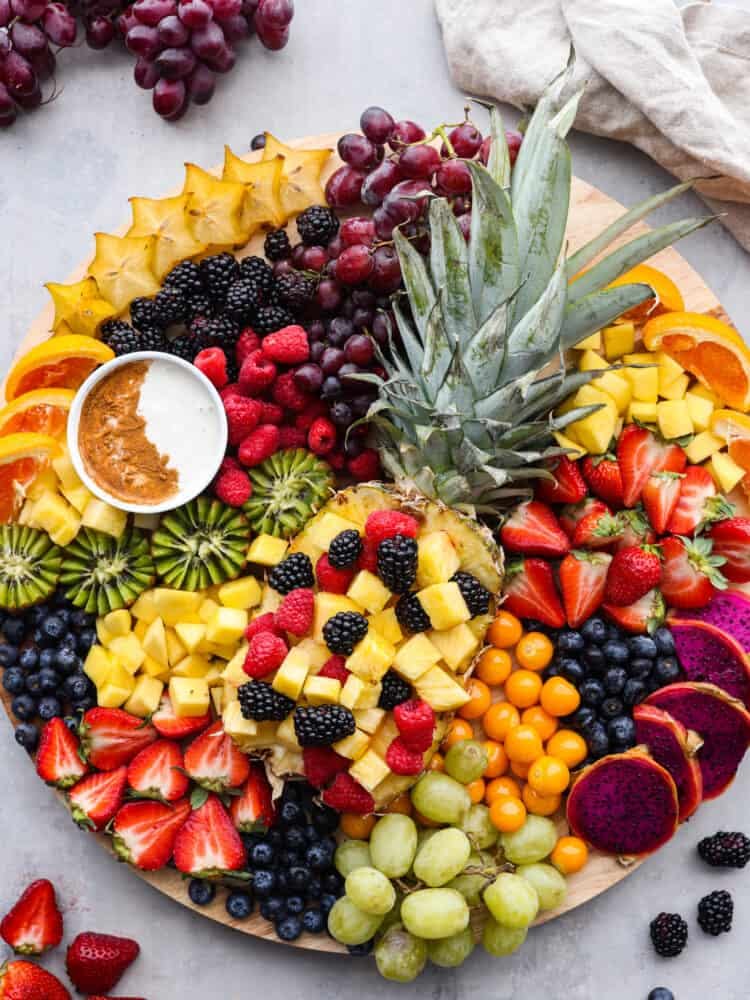 A wooden board with fruit arranged on it. 