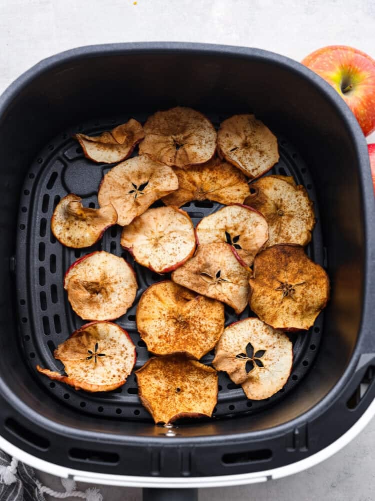 And air fryer basket with apple slices. 