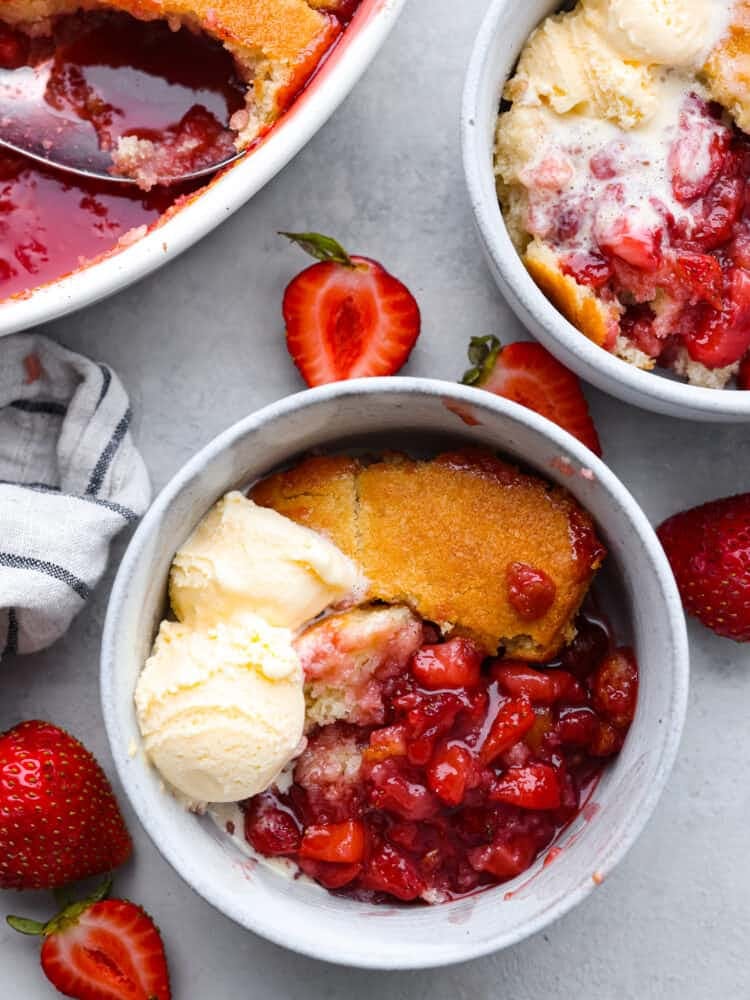 Strawberry cobbler in a bowl with some ice cream on top. 