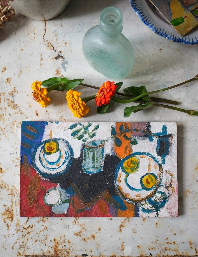 Still life arrangement with flowers and painting.