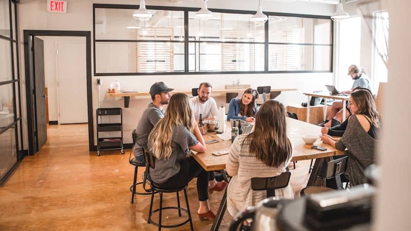 A room full of people sitting at tables, probably collaborating. Maybe having lunch.