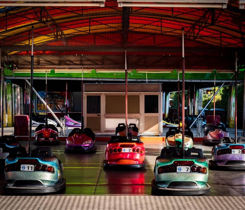 Colourful bumper cars spread out over a black floor.