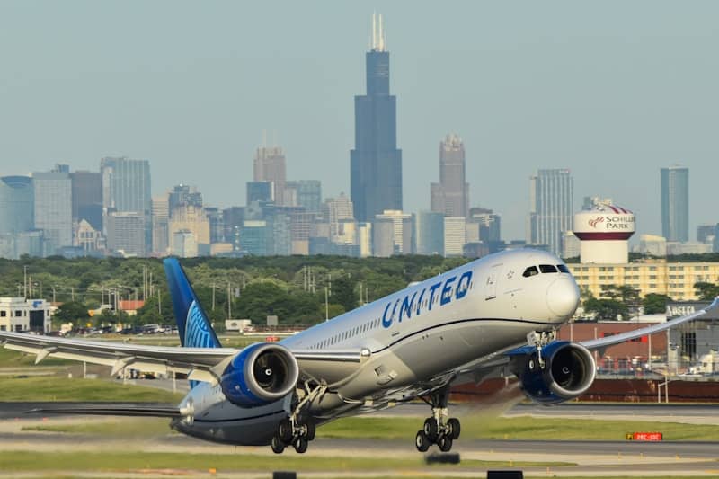 United airplane taking off with city skyline in background
