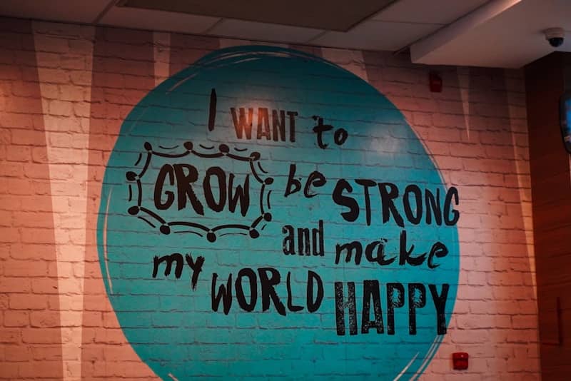 Wall mural with inspirational quote about growth and happiness