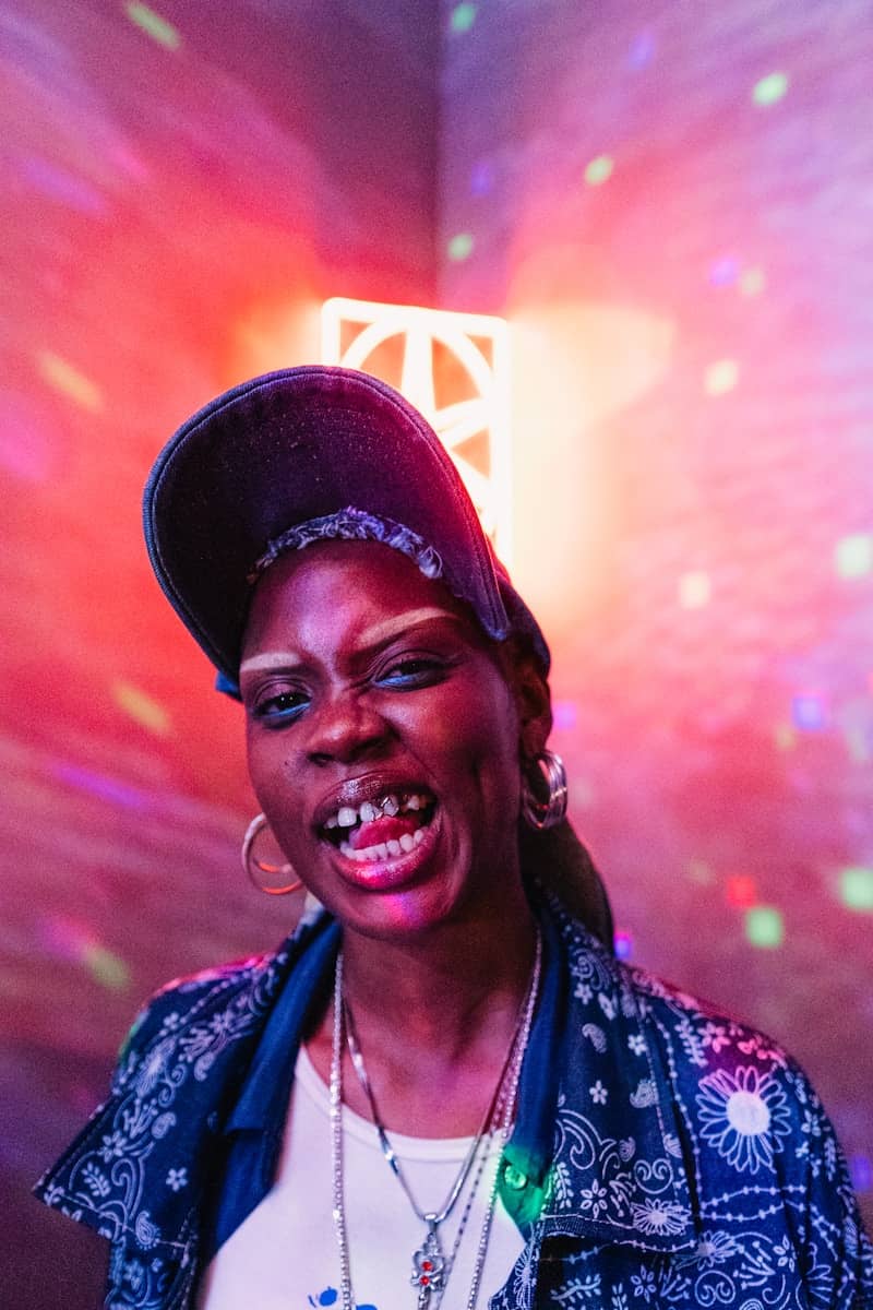 Person posing with an intense expression in colorful lighting.