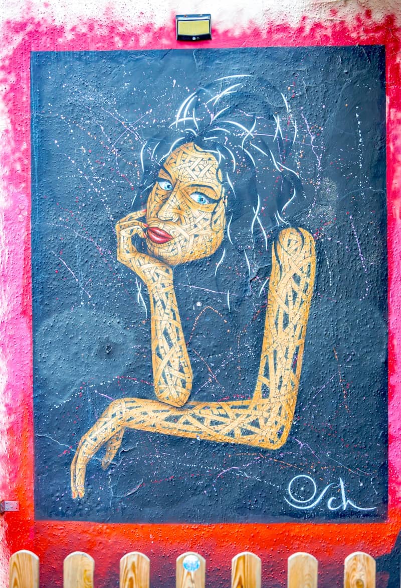 Woman's face with textured arms and dark background