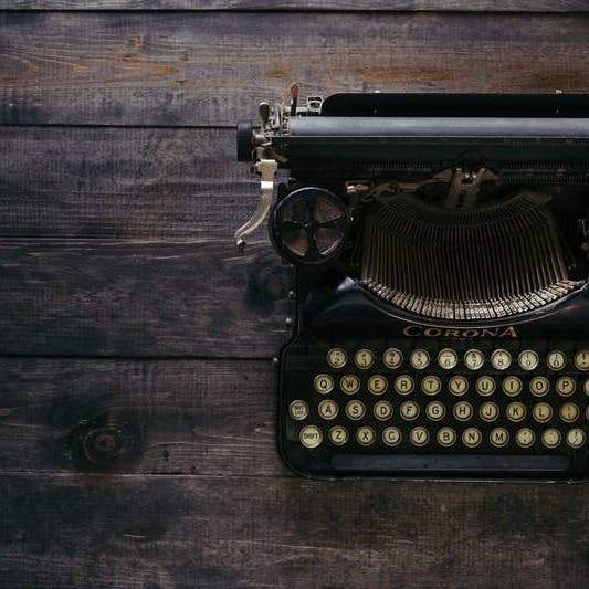 black Corona typewriter on brown wood planks