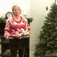 woman throwing christmas ornaments on tree