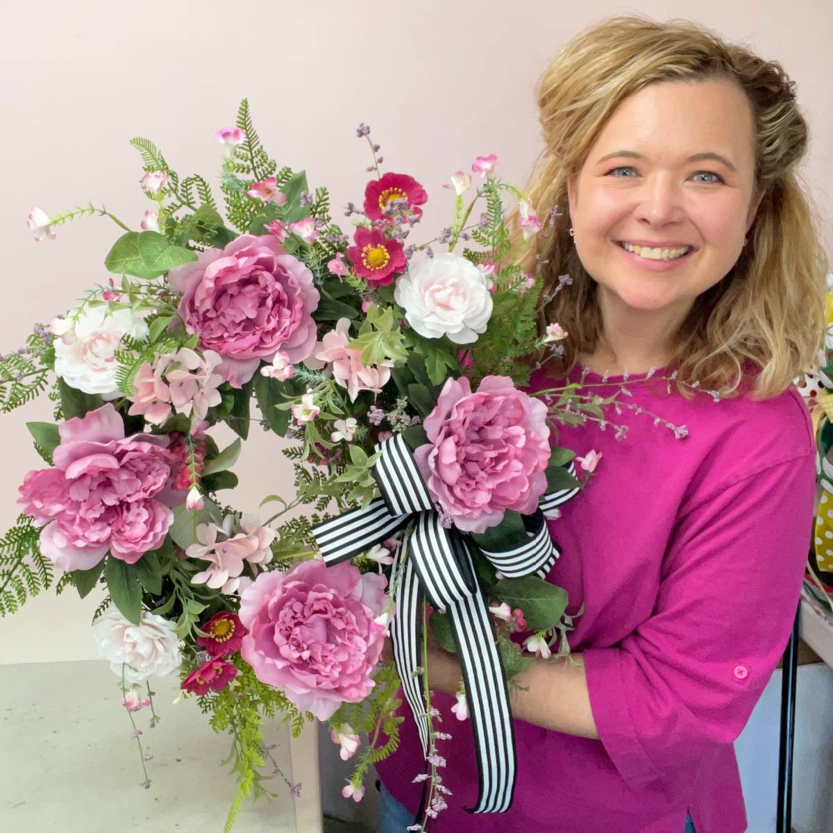 Ashley Greenwood, wreath designer holding a wreath she created