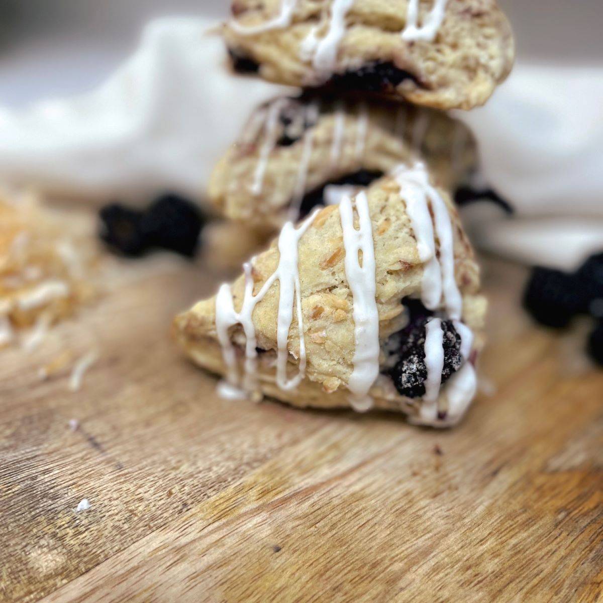 A blackberry coconut sourdough scone on a wooden cutting board.