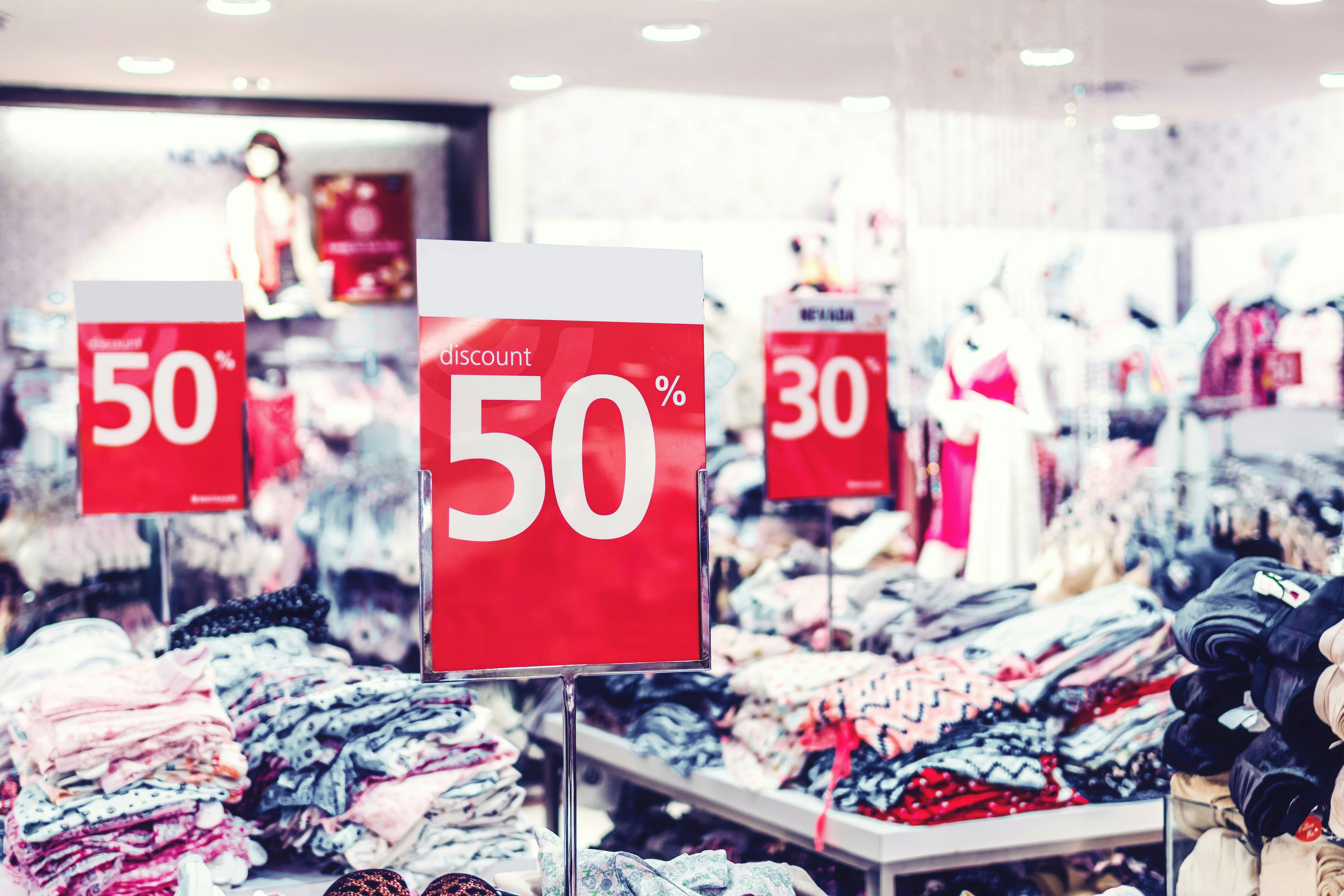 A store with piles of clothing at a 30 to 50 percent discount.