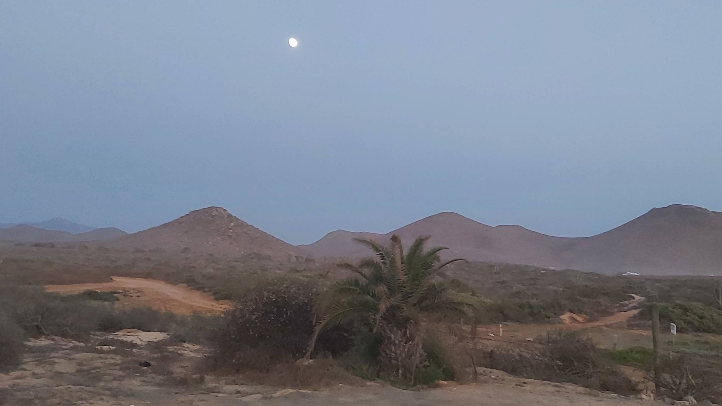 moon rising over desert and mountains