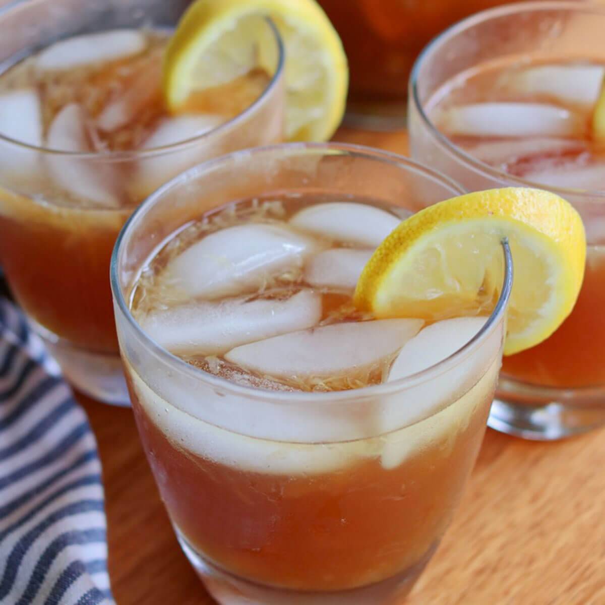 A glass of healthy lemonade with ice cubes garnished with a lemon slice.