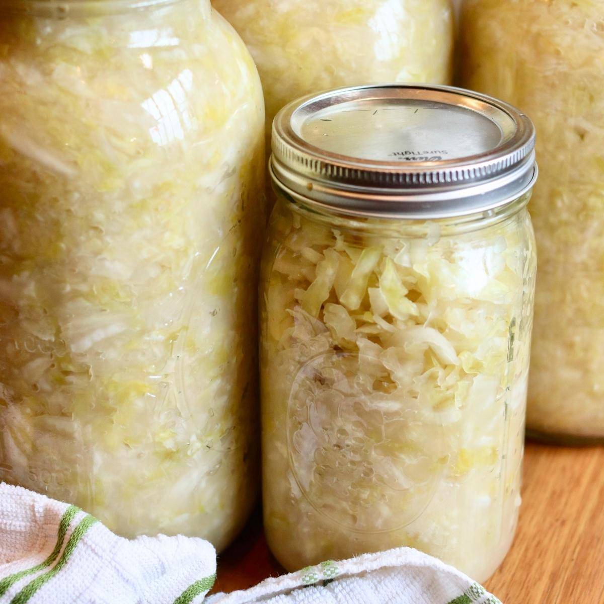 Jars of homemade sauerkraut on a table.