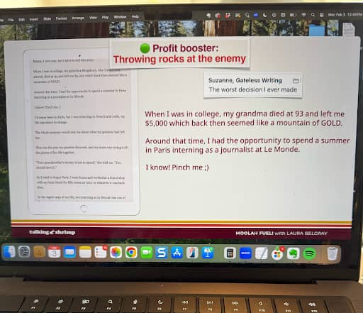 A laptop screen displays a writing course or presentation slide from "MOOLAH FUEL with Laura Belgray" on a website called "talking shrimp." The slide features the headline "Profit booster: Throwing rocks at the enemy" in red and green text. Below, a writing sample is labeled "Suzanne, Gateless Writing – The worst decision I ever made." The text describes how Suzanne's grandmother died when she was in college and left her $5,000, which felt like a fortune. She used the money to intern at Le Monde in Paris. The slide ends with the sentence, "I know! Pinch me ;)" The desktop background shows a forest, and various app icons (Safari, Mail, Calendar, Notes, Messages, Spotify, etc.) are visible in the macOS dock at the bottom.